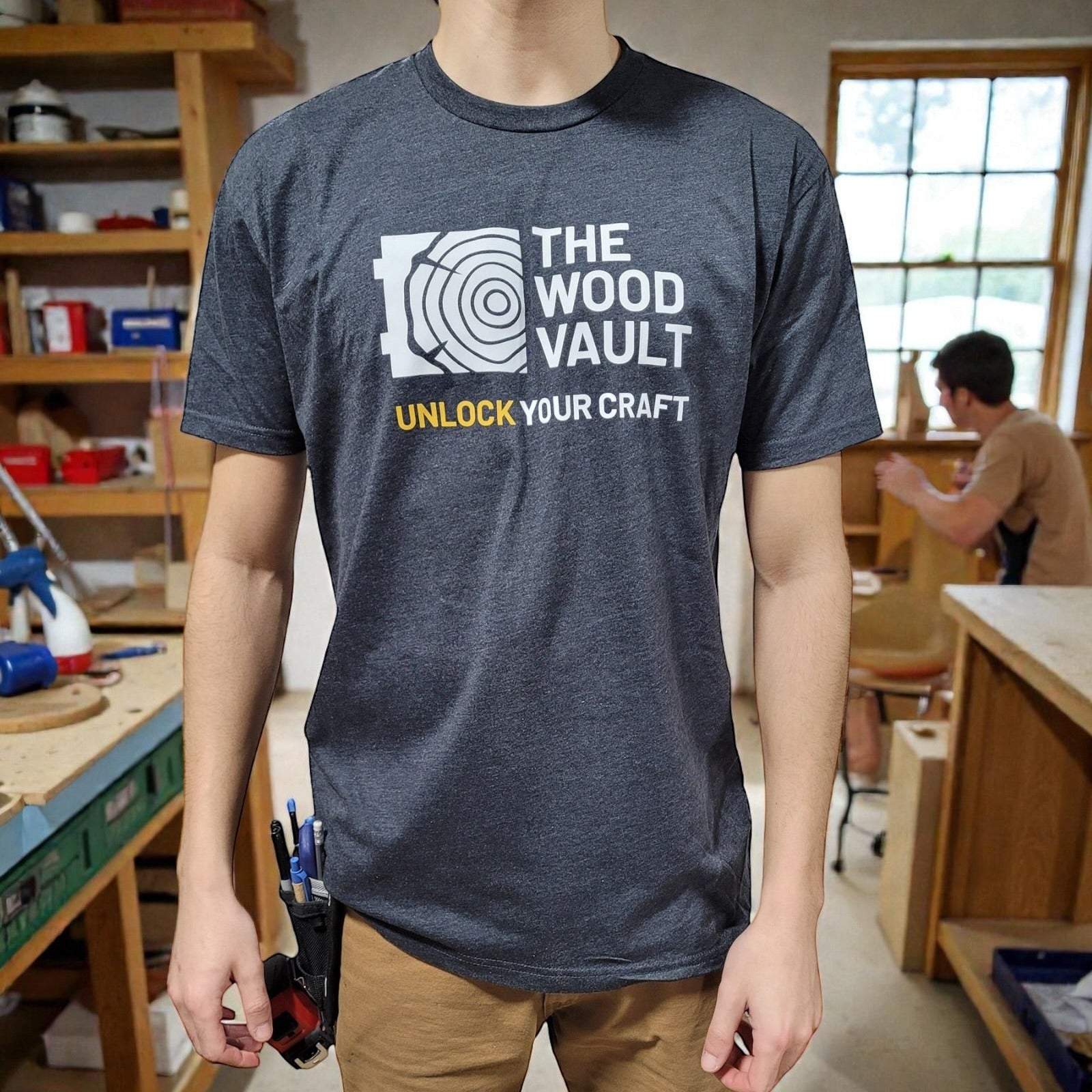 Person wearing a t-shirt with 'The Wood Vault' logo in a workshop setting